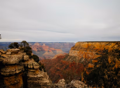 Expansive view of Grand Canyon's rocky landscape under cloudy sky